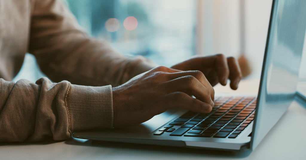 Close up of hands typing on computer.